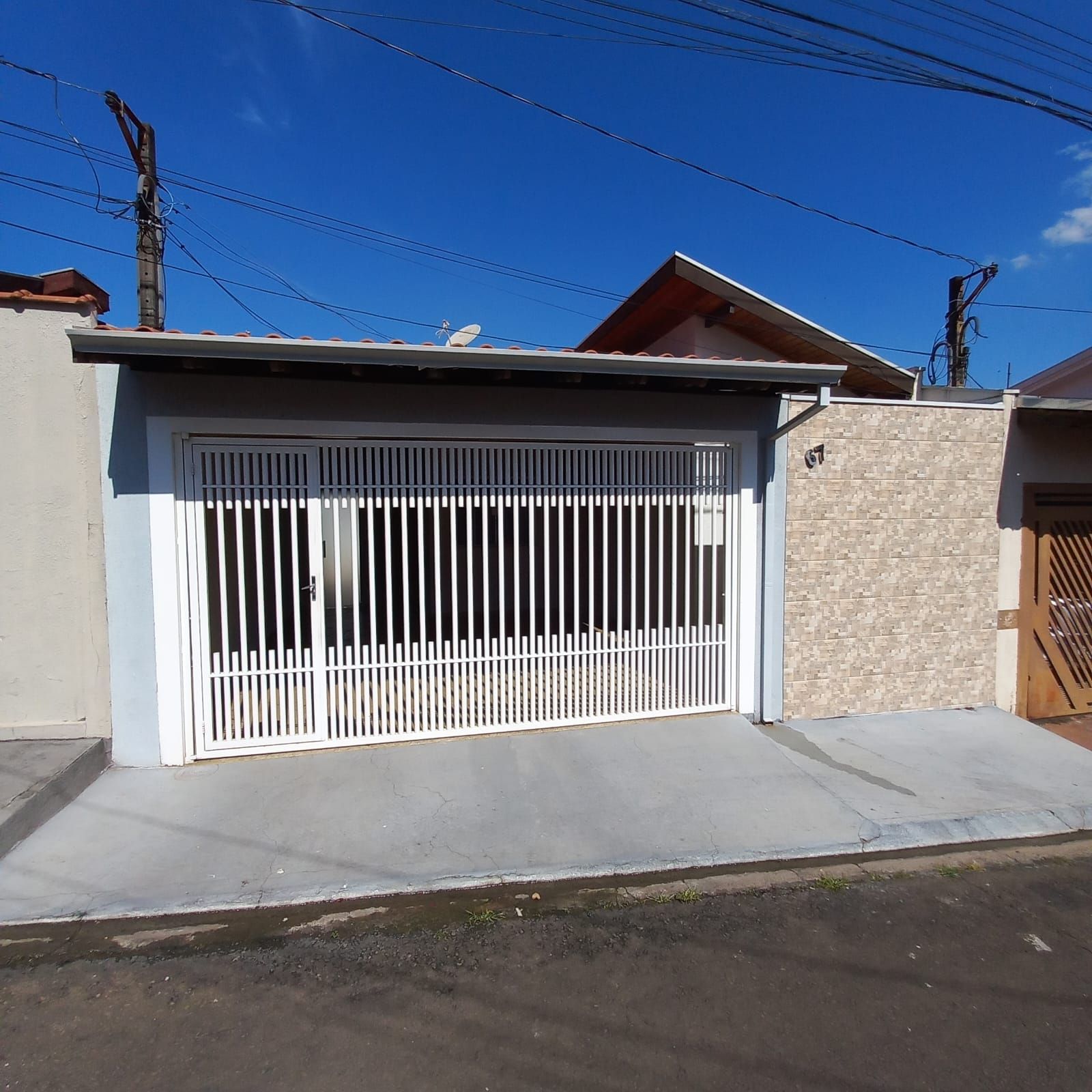 Fachada da casa 67 no Condomínio Santa Cruz, com portão de garagem